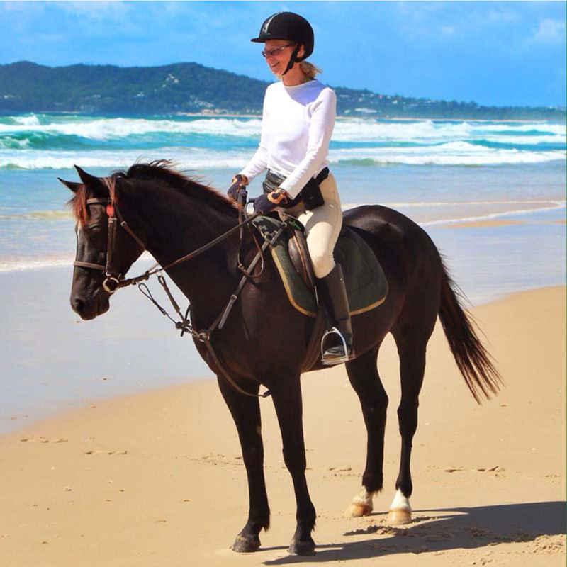 kinkin a person riding a horse on a beach